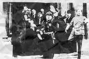 Первые минуты после покушения на Думера. Потрясённые участники книжной ярмарки и полицейские держат раненого президента (видны его ботинки)