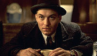 В роли киллера Харлена Магвайра («Проклятый путь», 2002)