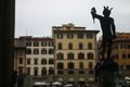 Wide view of square with silhouetted back view of Perseus at right